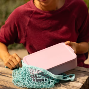 Vista superior de un tupper bento almuerzo con diferentes alimentos organizados en sus compartimentos